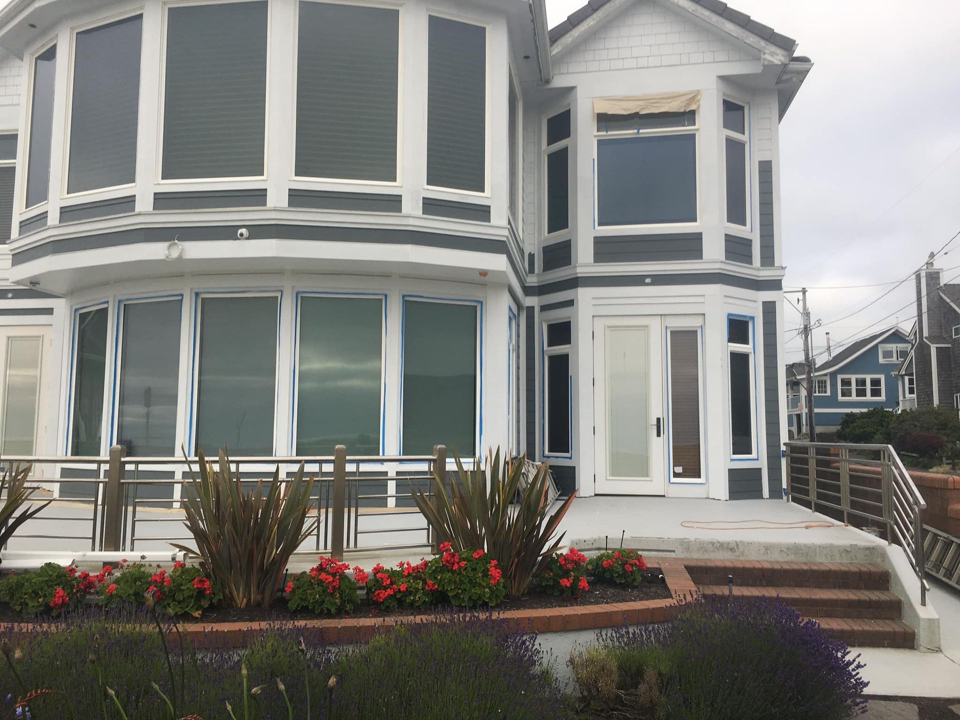A large house with a lot of windows and flowers in front of it
