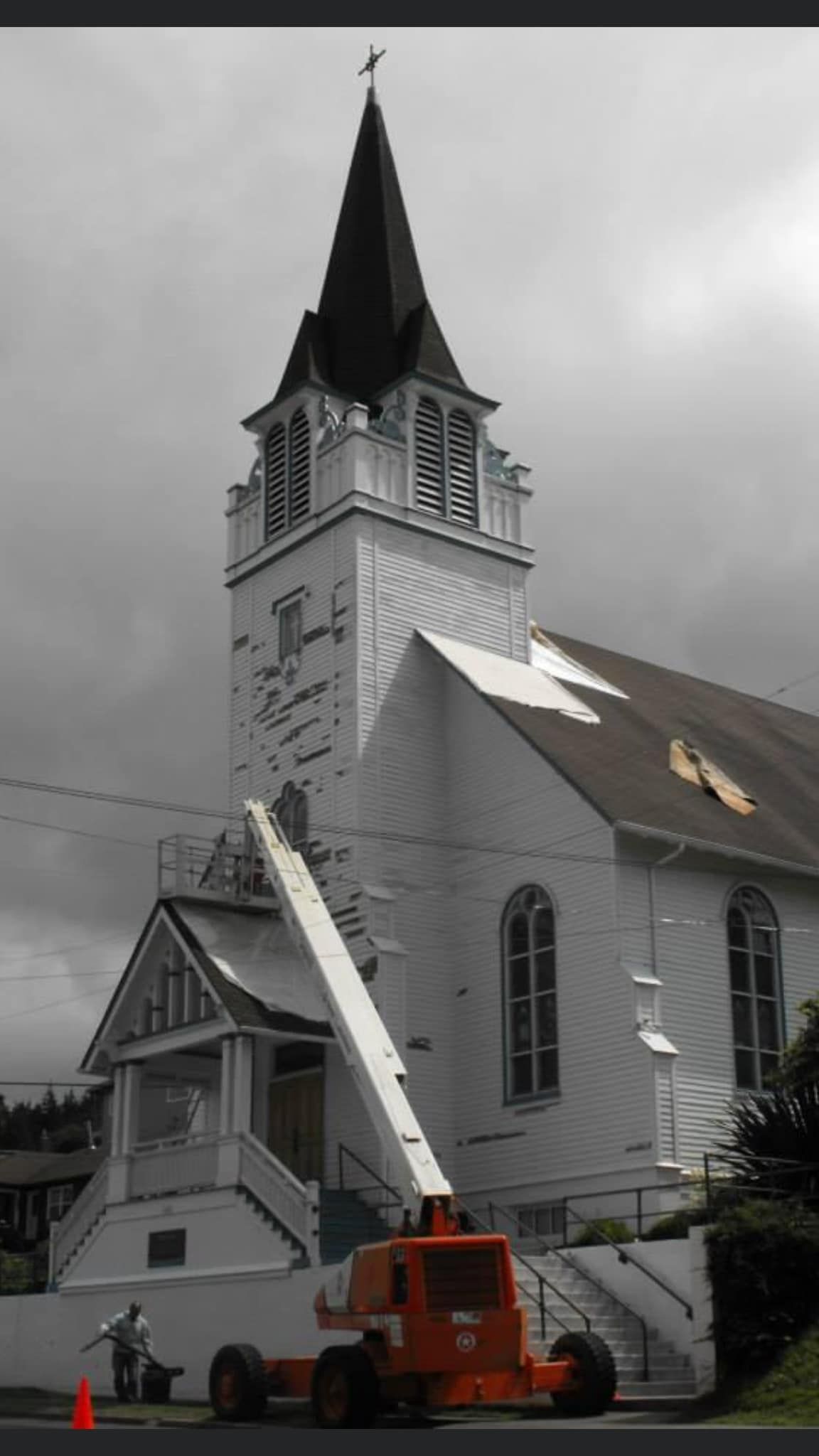 A large white church with a crane in front of it