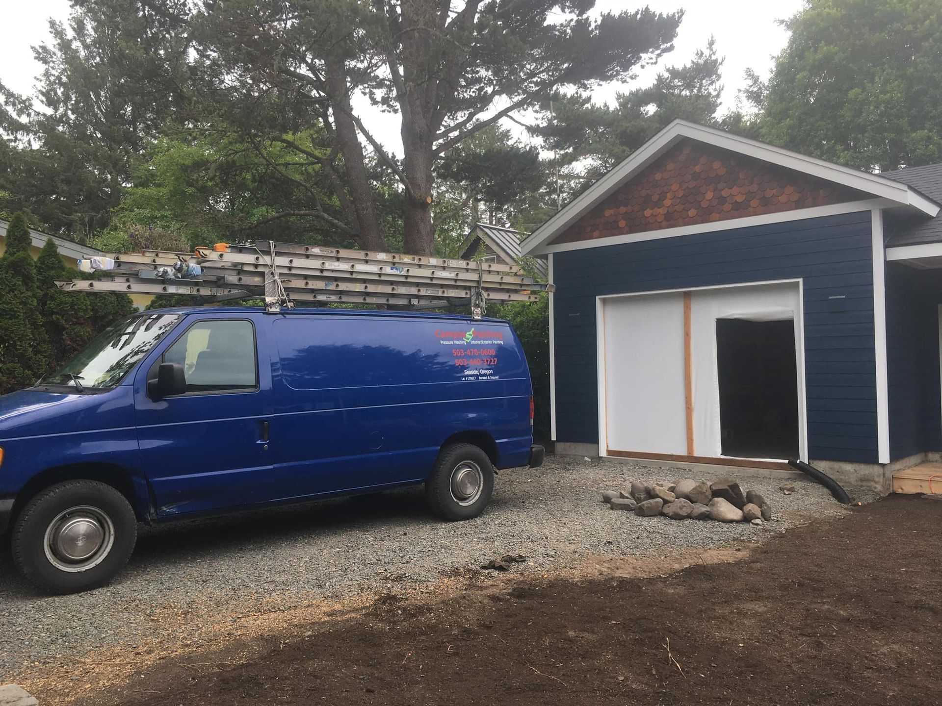 A blue van is parked in front of a blue house