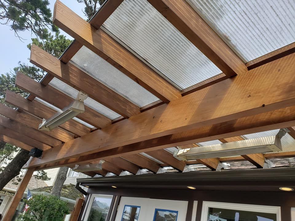 A wooden pergola with a clear plastic roof