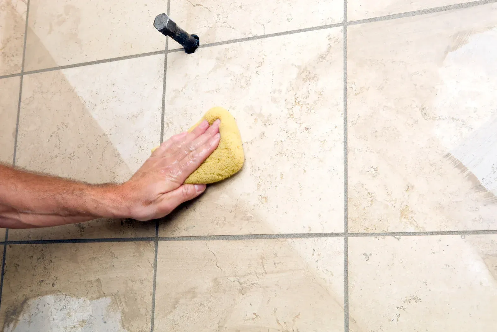 Carpet cleaning in progress, showing a before-and-after effect. The cleaner's head is visible, with clean carpet on the left.