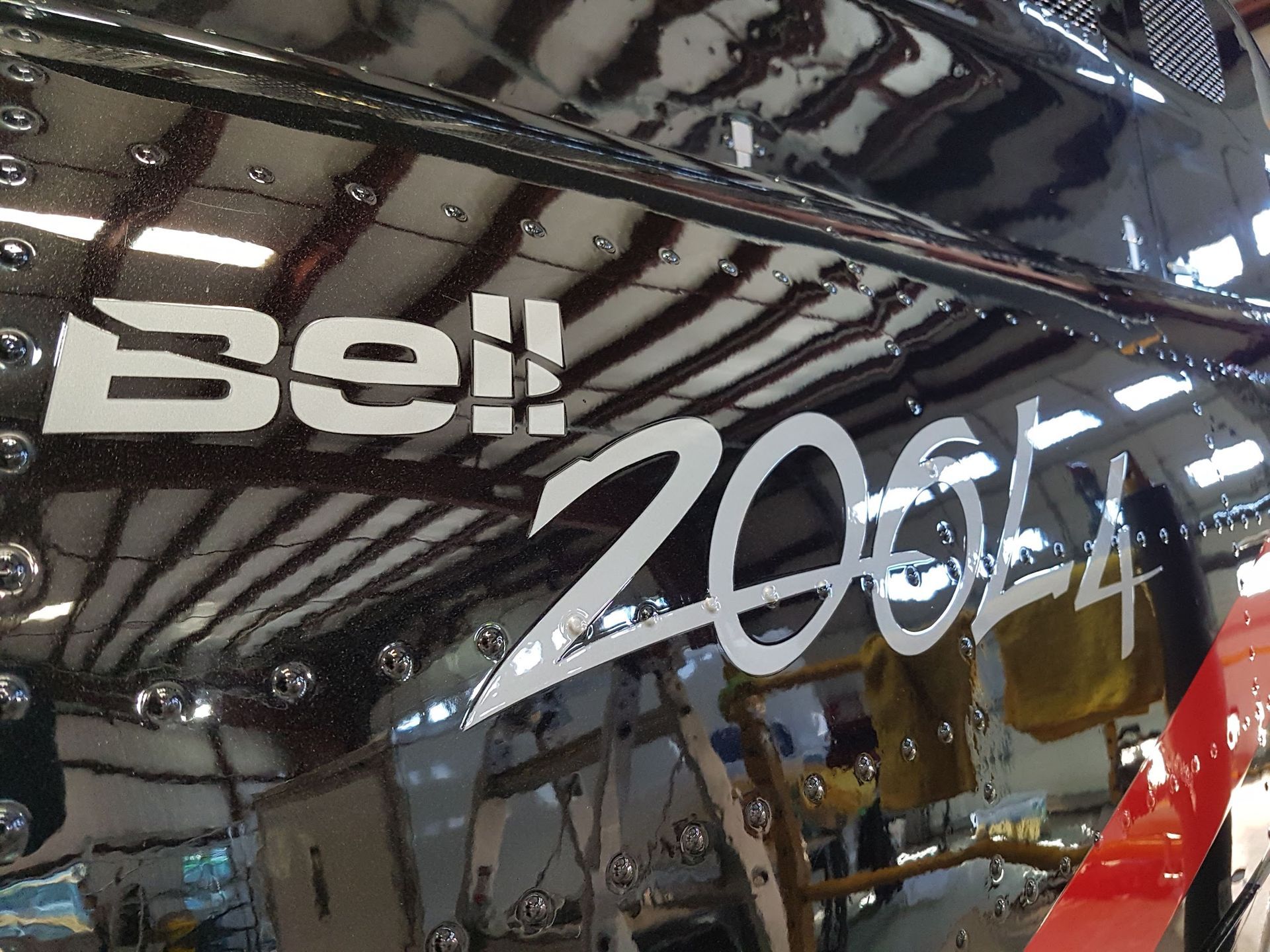 Close-up of a glossy black helicopter fuselage with the