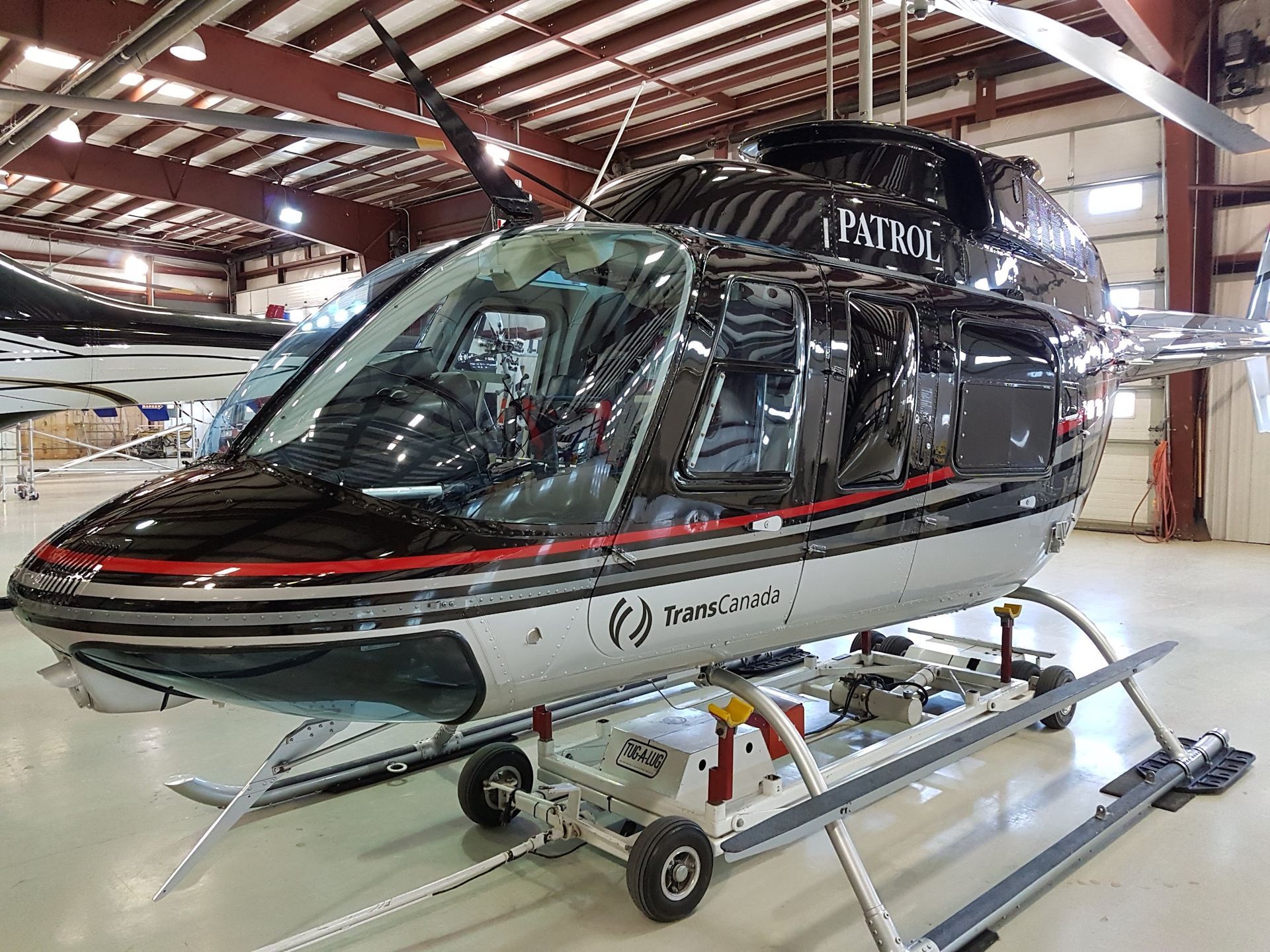 Black and silver helicopter in a hangar with the word
