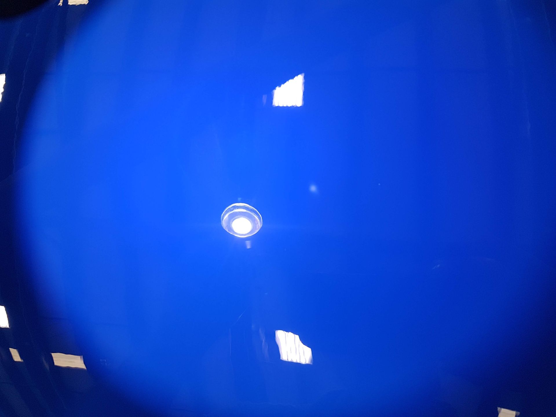 Blue ceiling with a recessed light fixture; light reflections are visible.