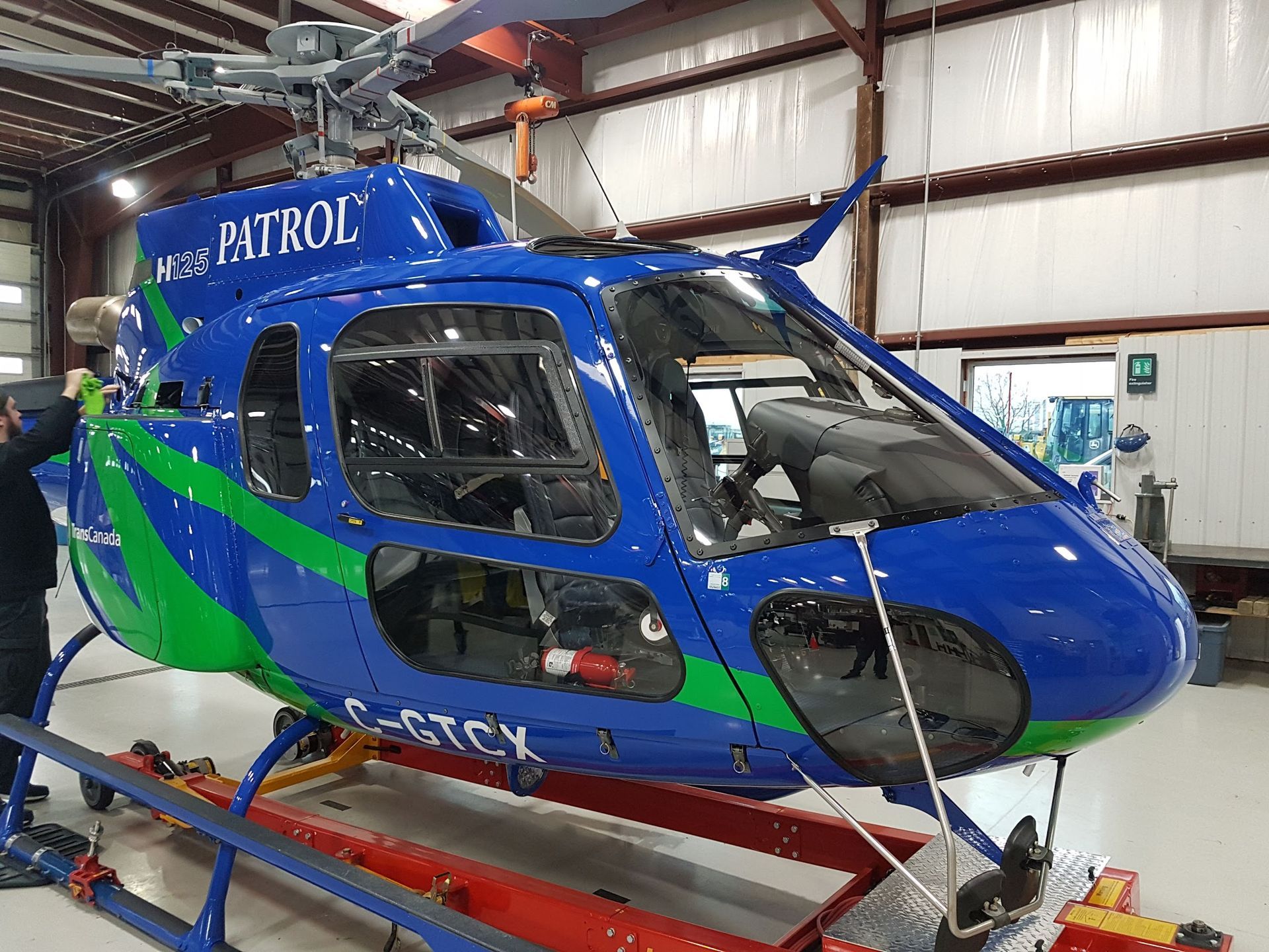Blue and green helicopter in a hangar with