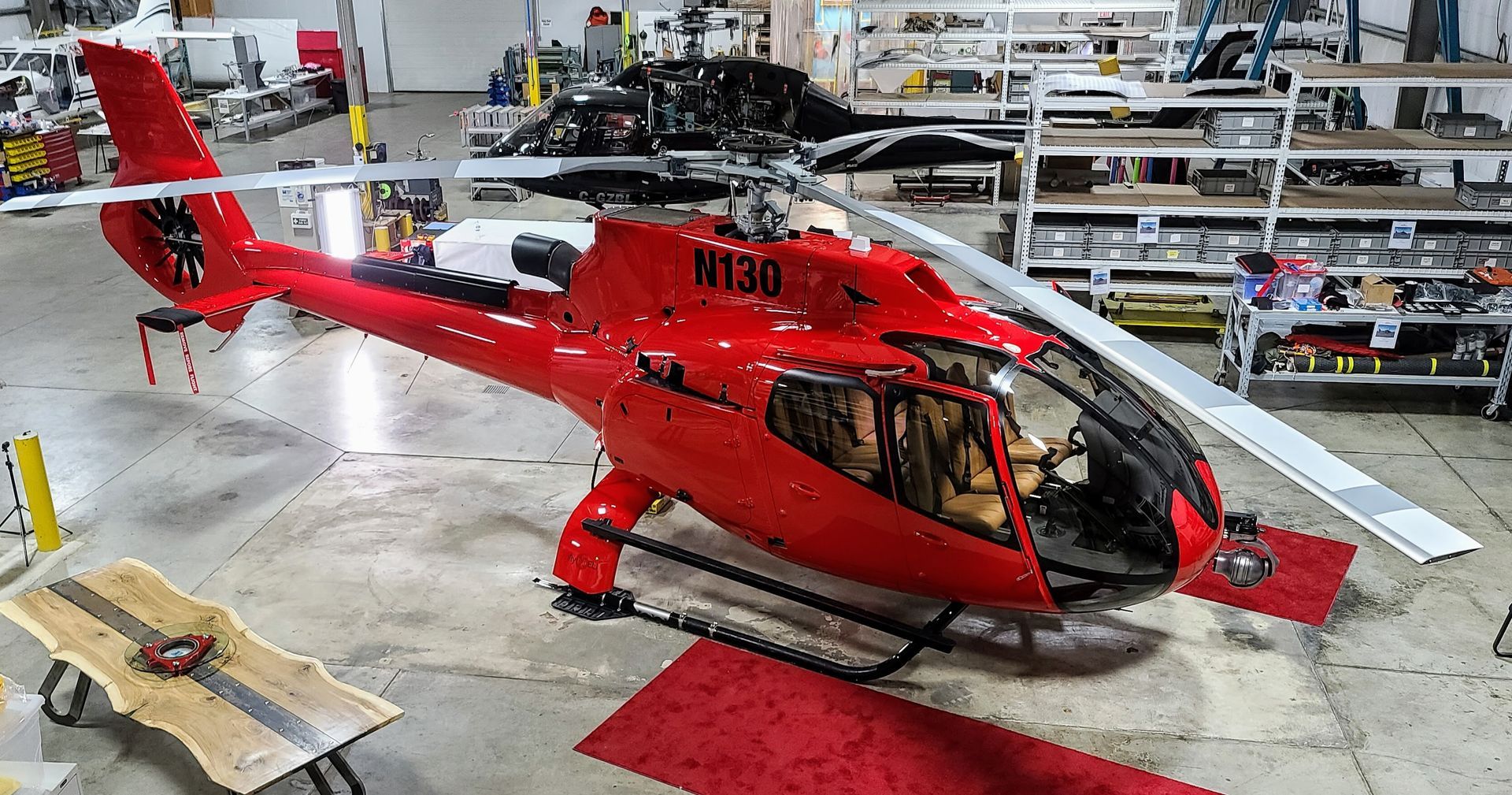 Red helicopter in a workshop, partially disassembled.