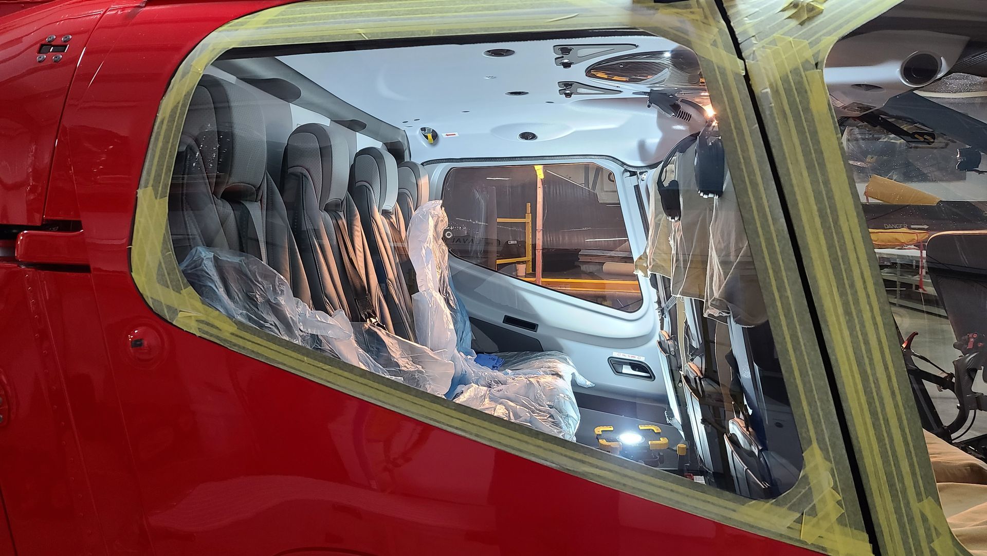 Red helicopter interior with seats visible through the open window, night setting.