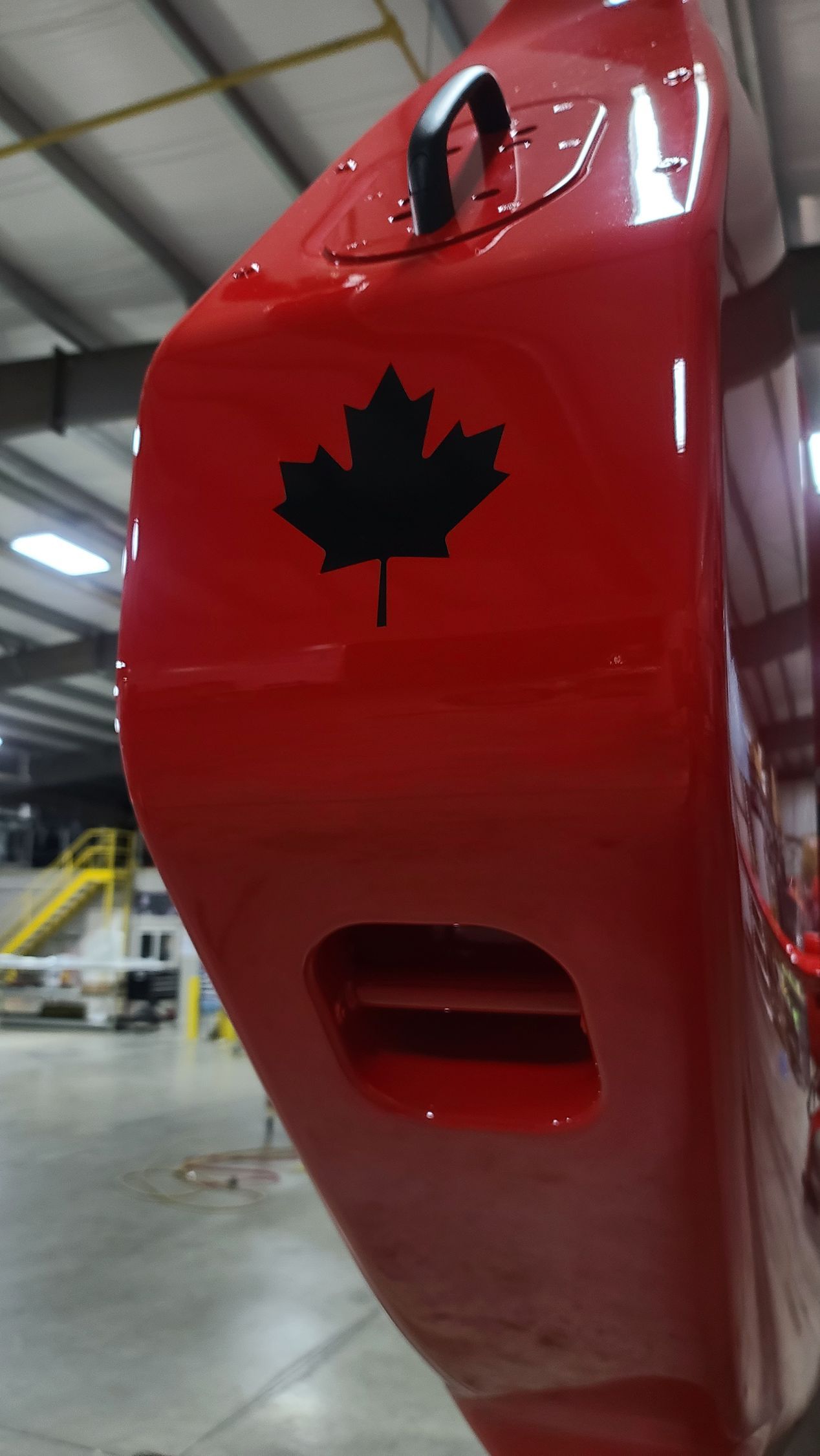Red helicopter tail with black Canadian maple leaf.