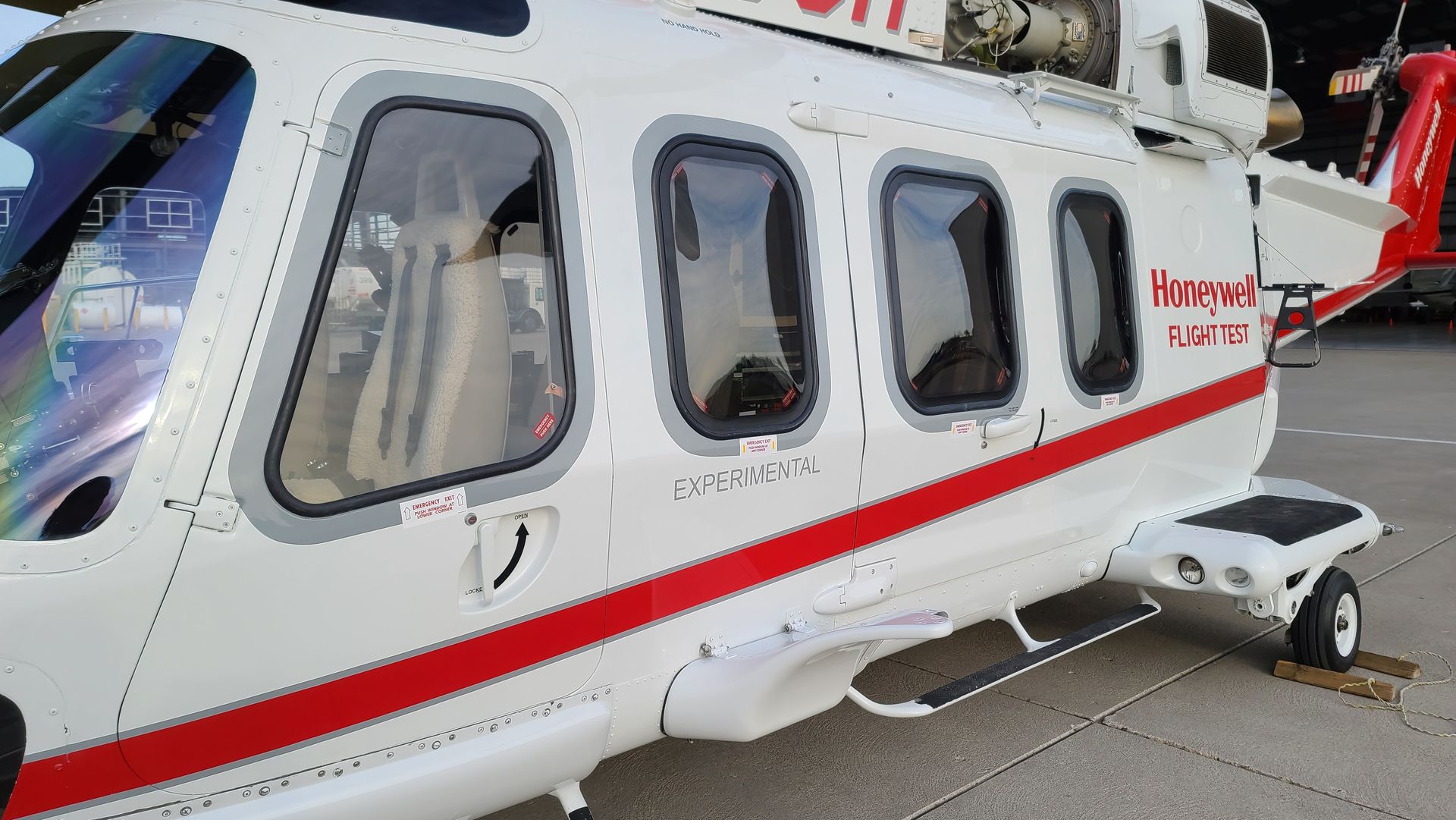 White helicopter with red stripes and the words