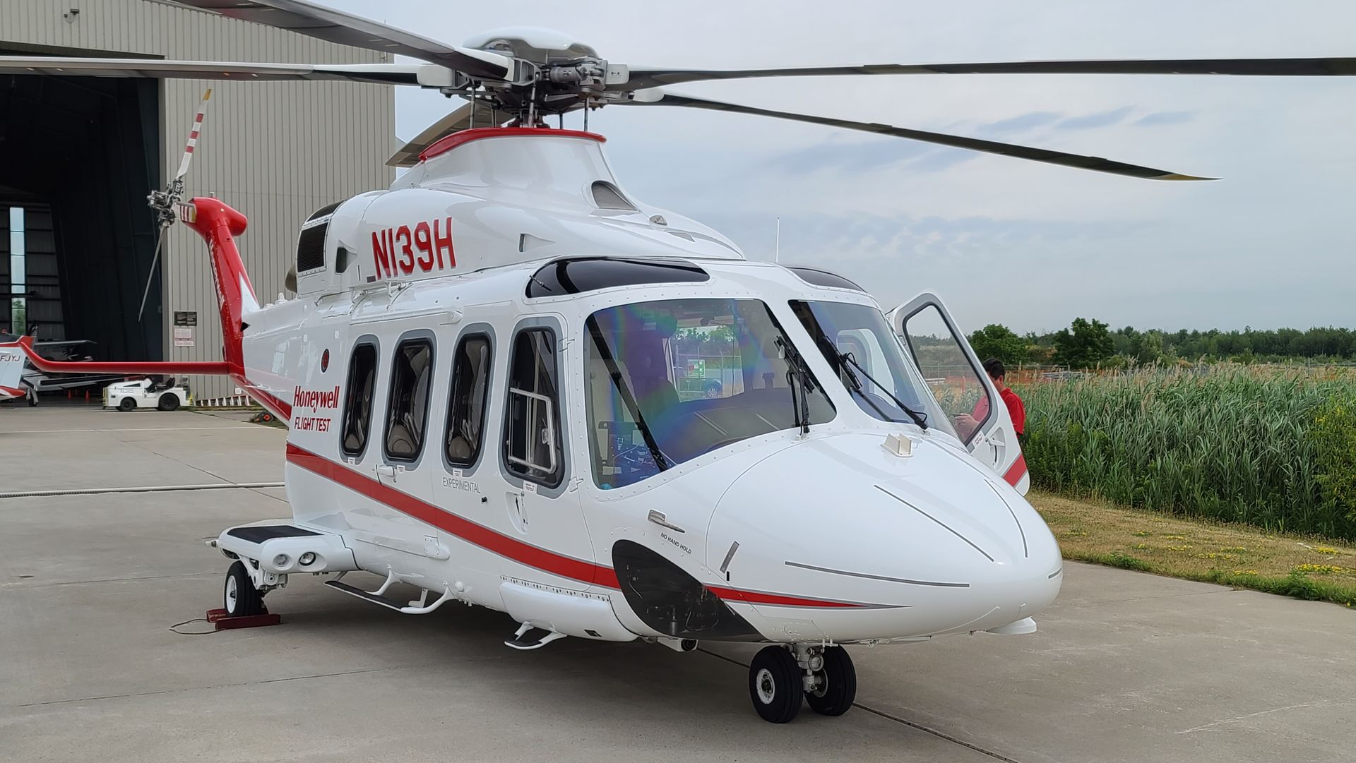 White and red medical helicopter on a tarmac, door open.