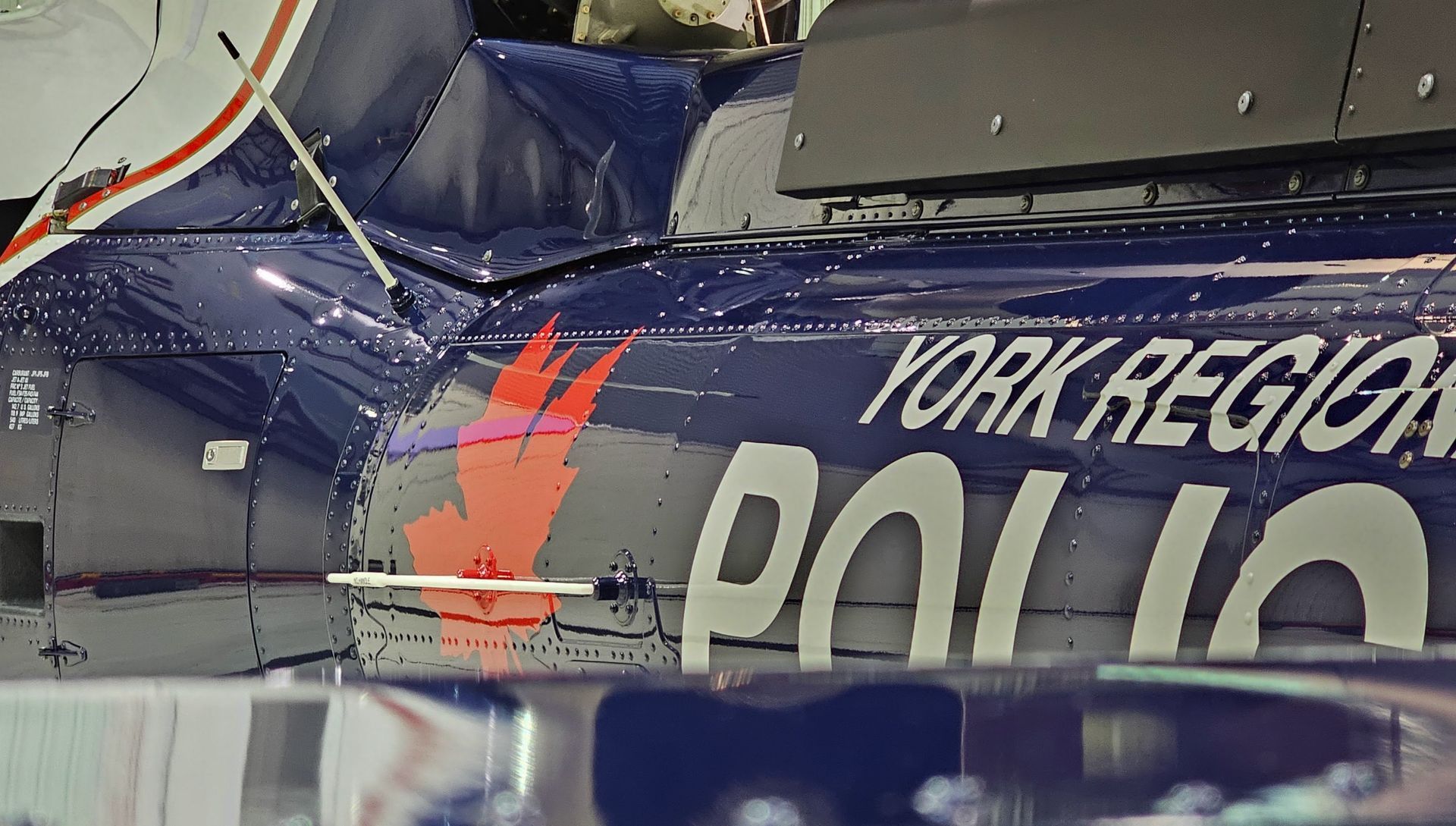 Close-up of a York Regional Police helicopter with logo and red maple leaf on blue fuselage.