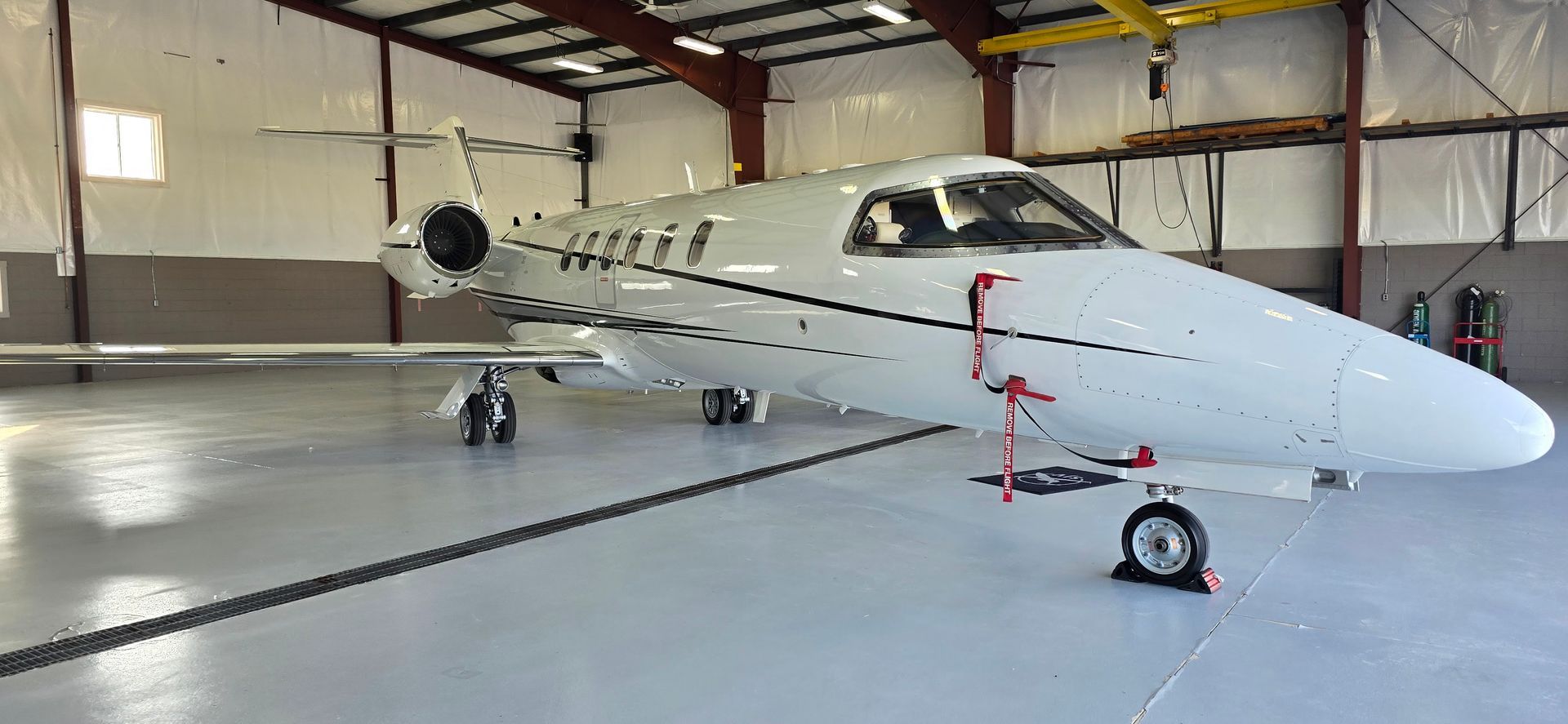White private jet in a hangar.