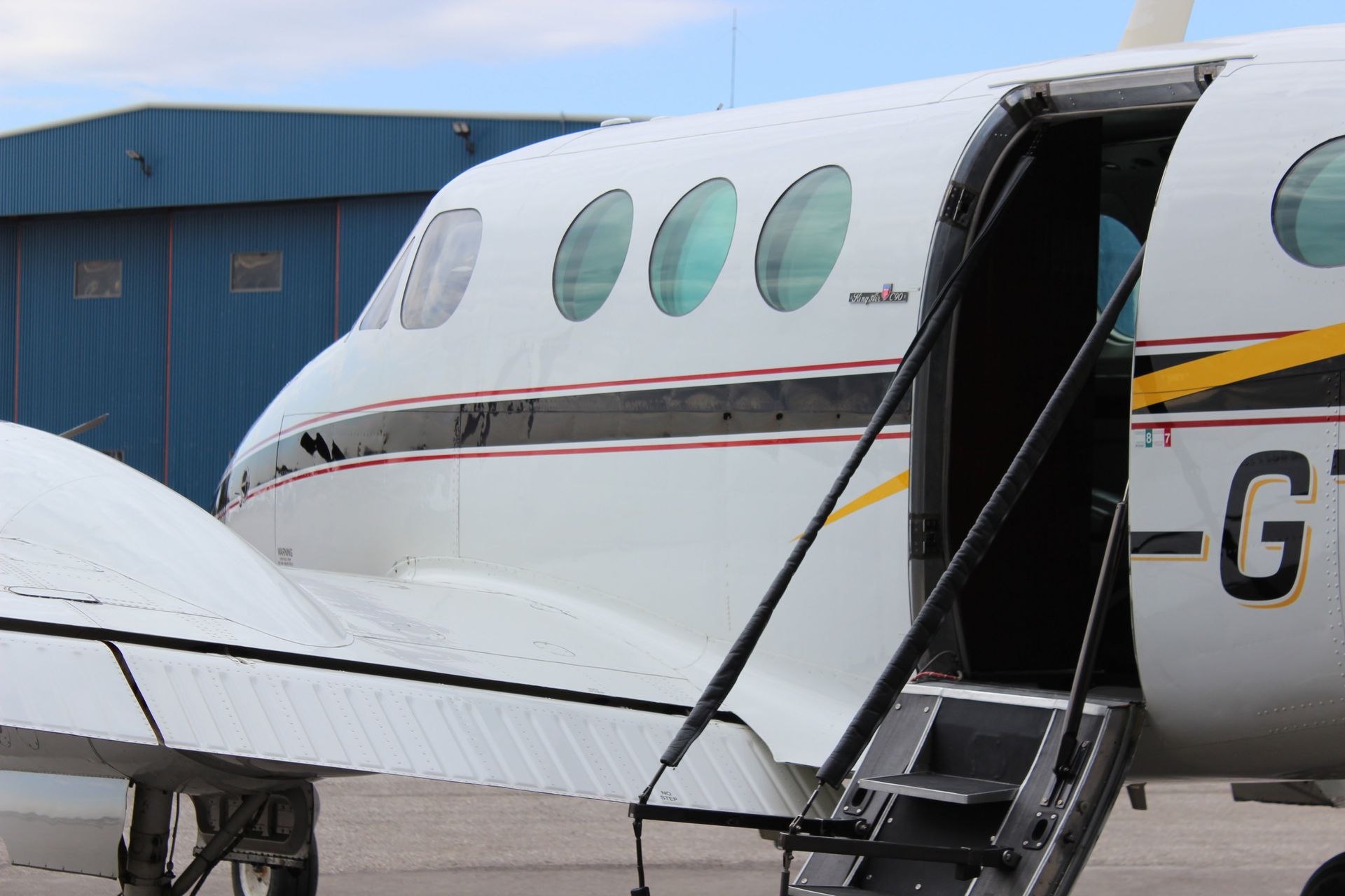 White airplane with open door and boarding steps. Exterior view.