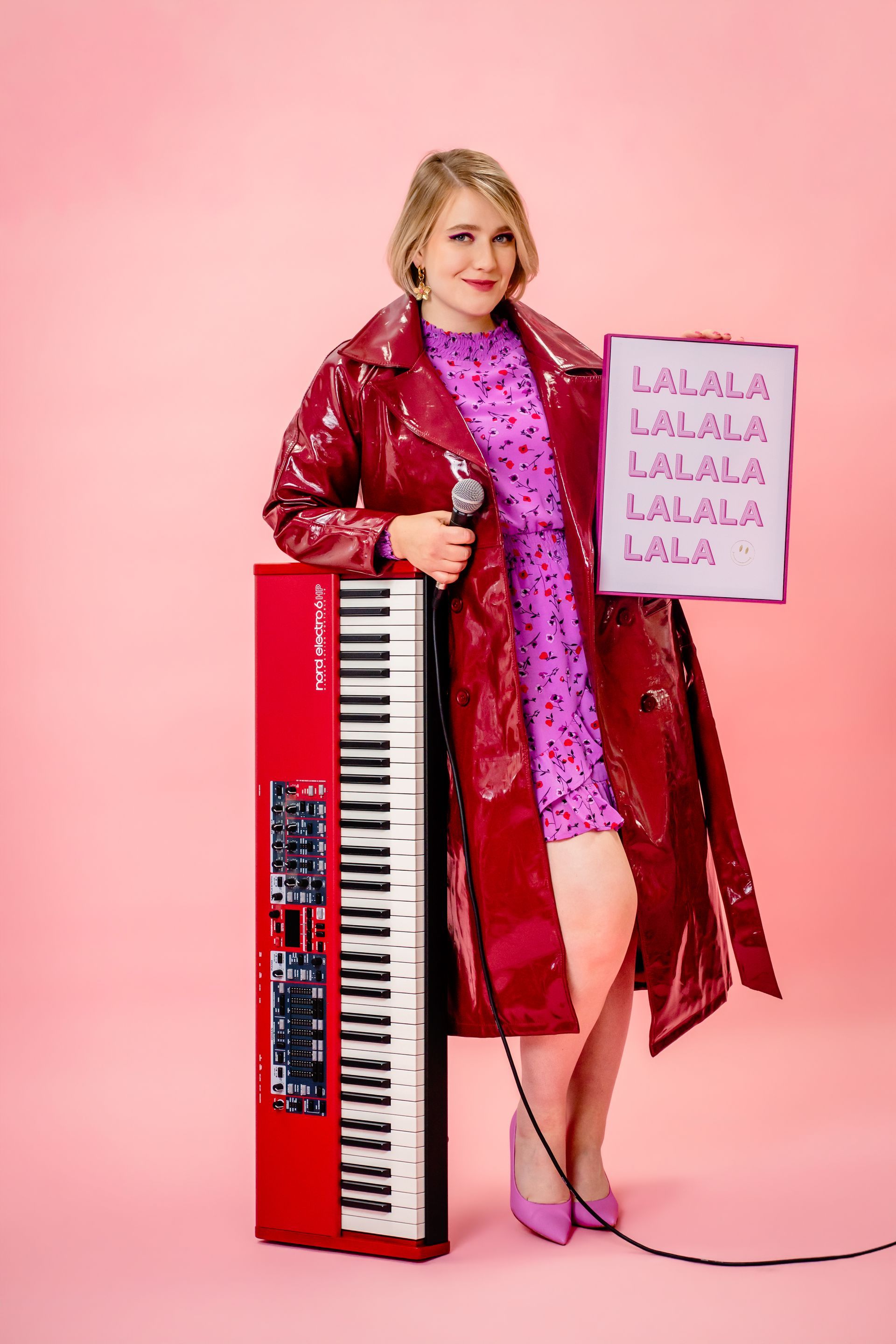 Woman holding a pink wavy mirror, reflecting her smiling image on a magenta background.