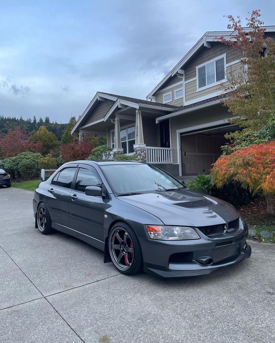 Gray Mitsubishi Lancer Evolution parked on a driveway in front of a house.