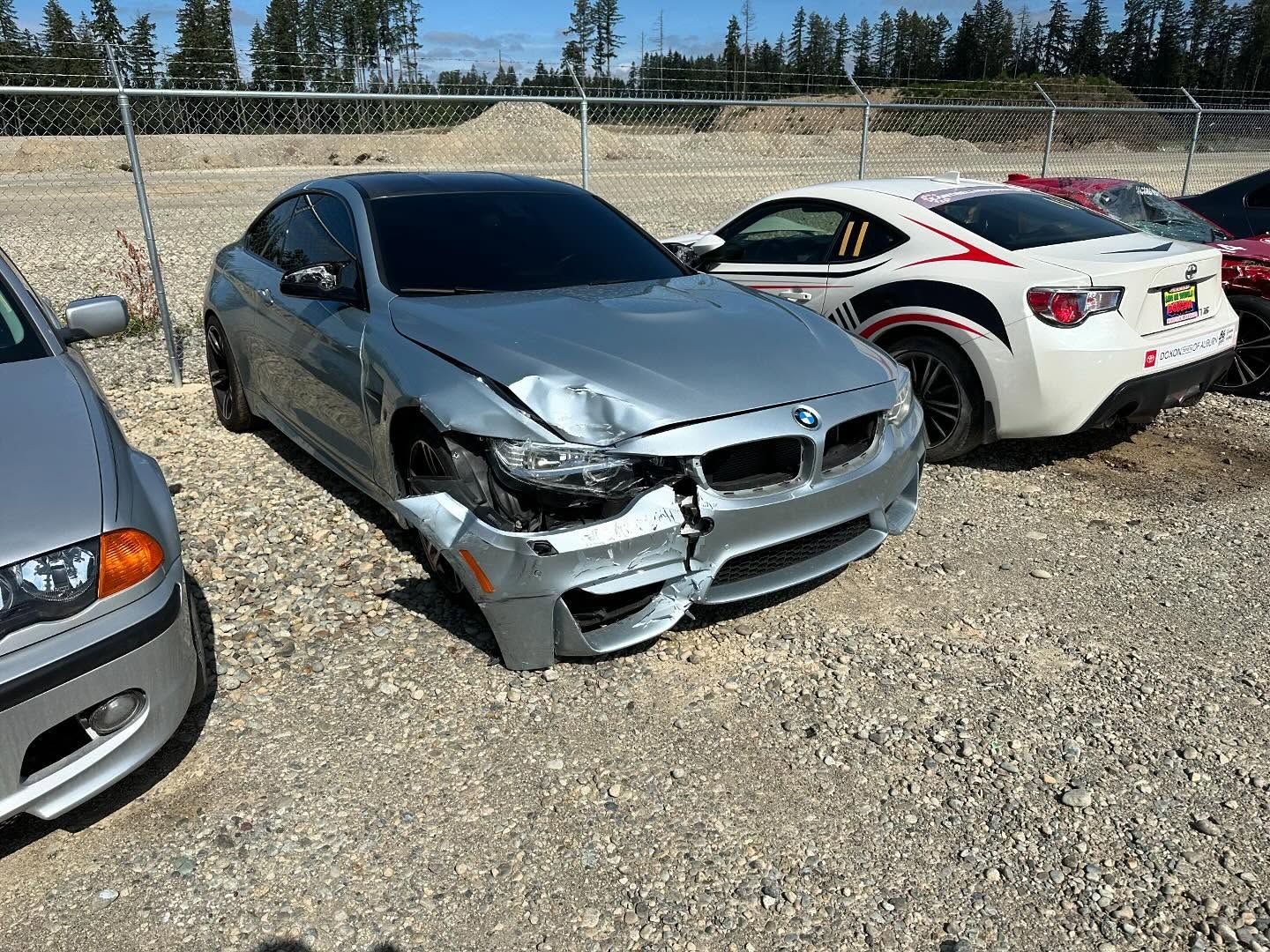 Damaged silver BMW coupe; front end collision; parked in lot.