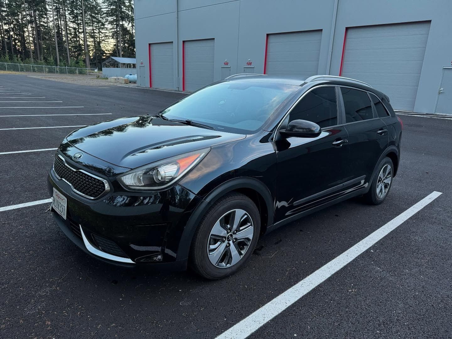 Black Kia Niro hybrid parked in a parking lot.
