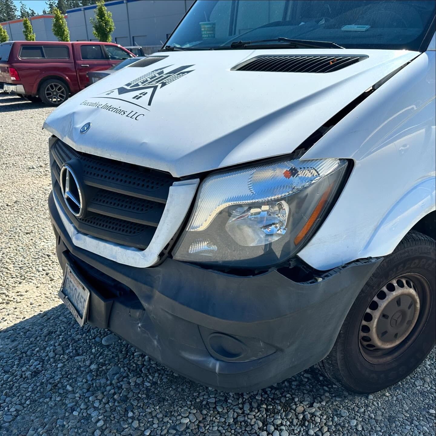White Mercedes-Benz van with front-end damage. Bumper and hood dented.