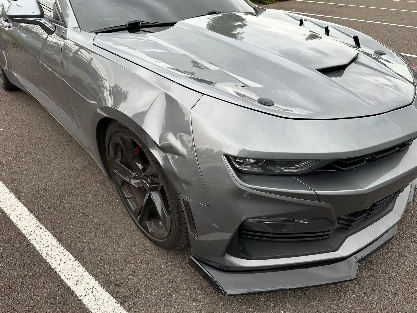 Gray Chevrolet Camaro with black accents, parked on asphalt.