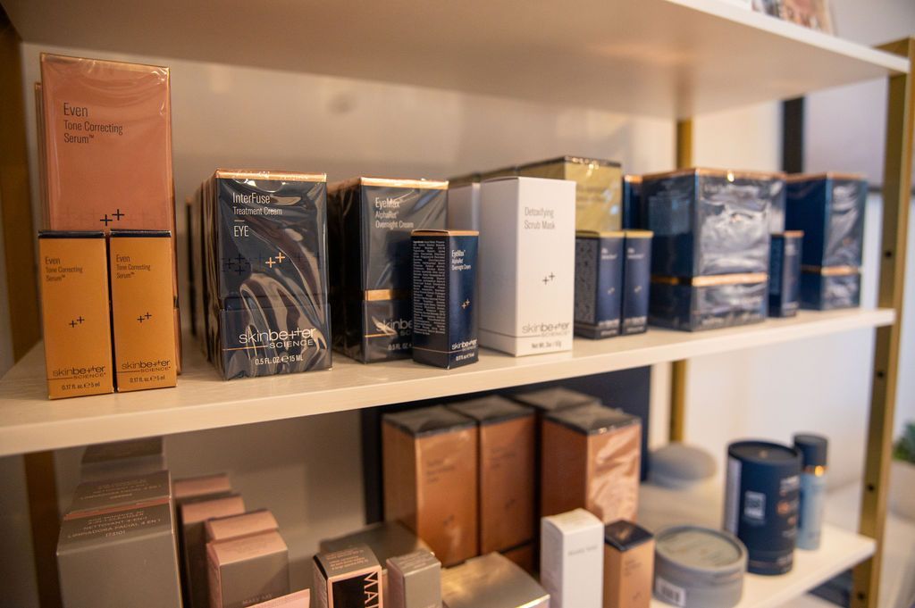 Shelves displaying various boxed cosmetic products in an interior setting, including perfumes and creams.