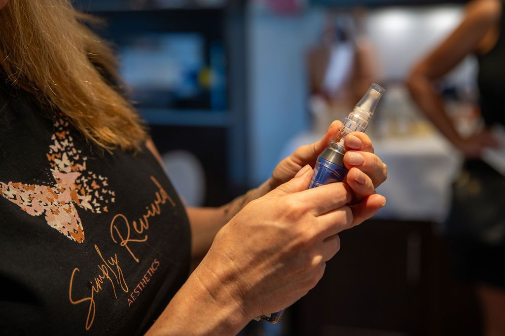 Person holding a medical device, with a blurred background of another person and interior space.