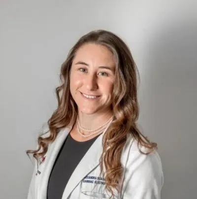 Smiling medical professional in a white coat against a gray background