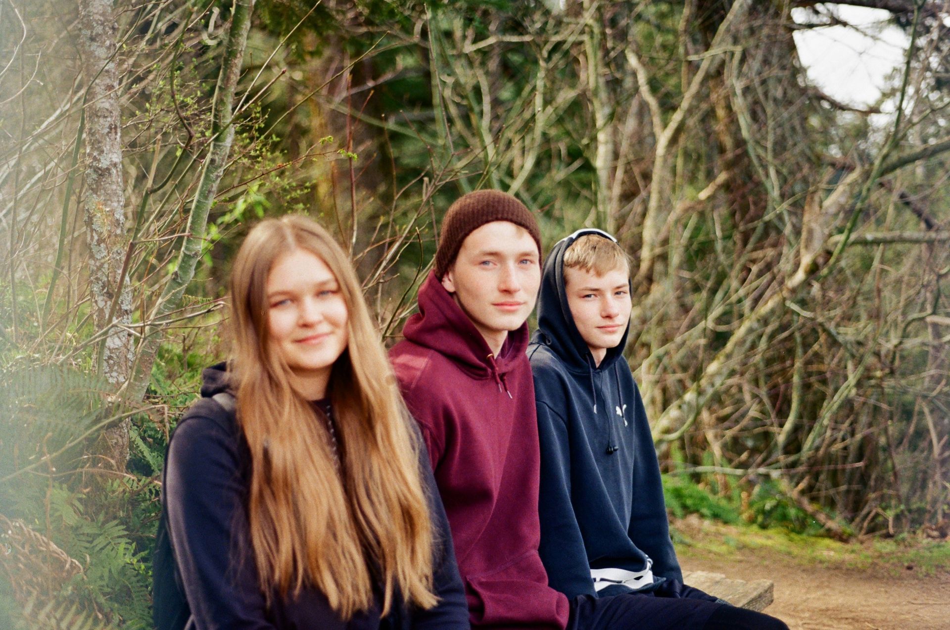 Photo of three teenagers looking into the camera with relaxed smiles