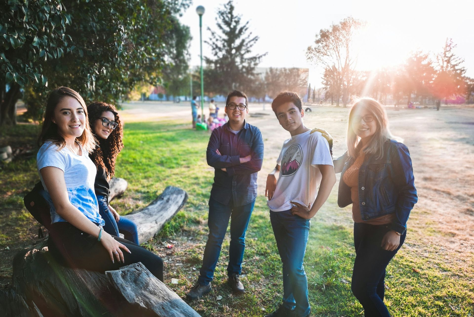Photo of 5 teenagers standing around a picnic table talking 