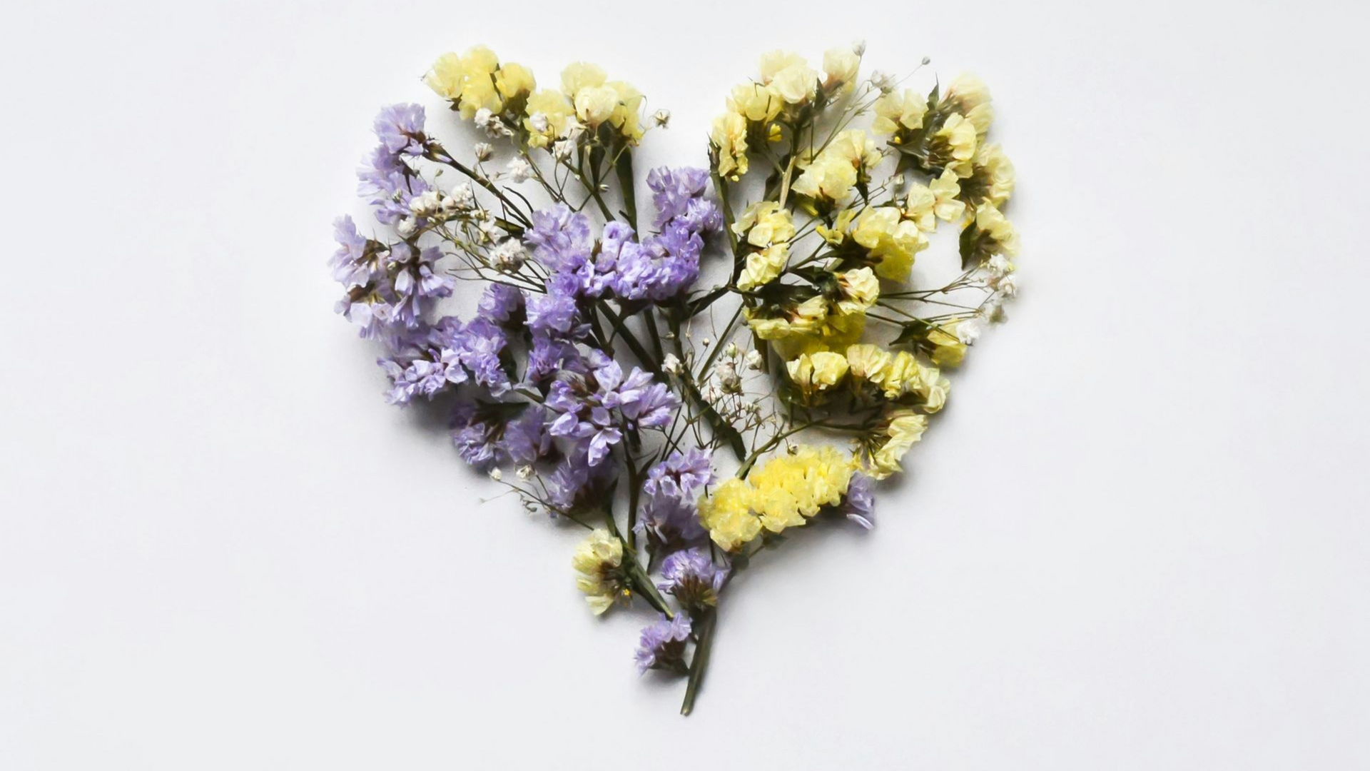 Purple and yellow flowers arranged in a heart shape