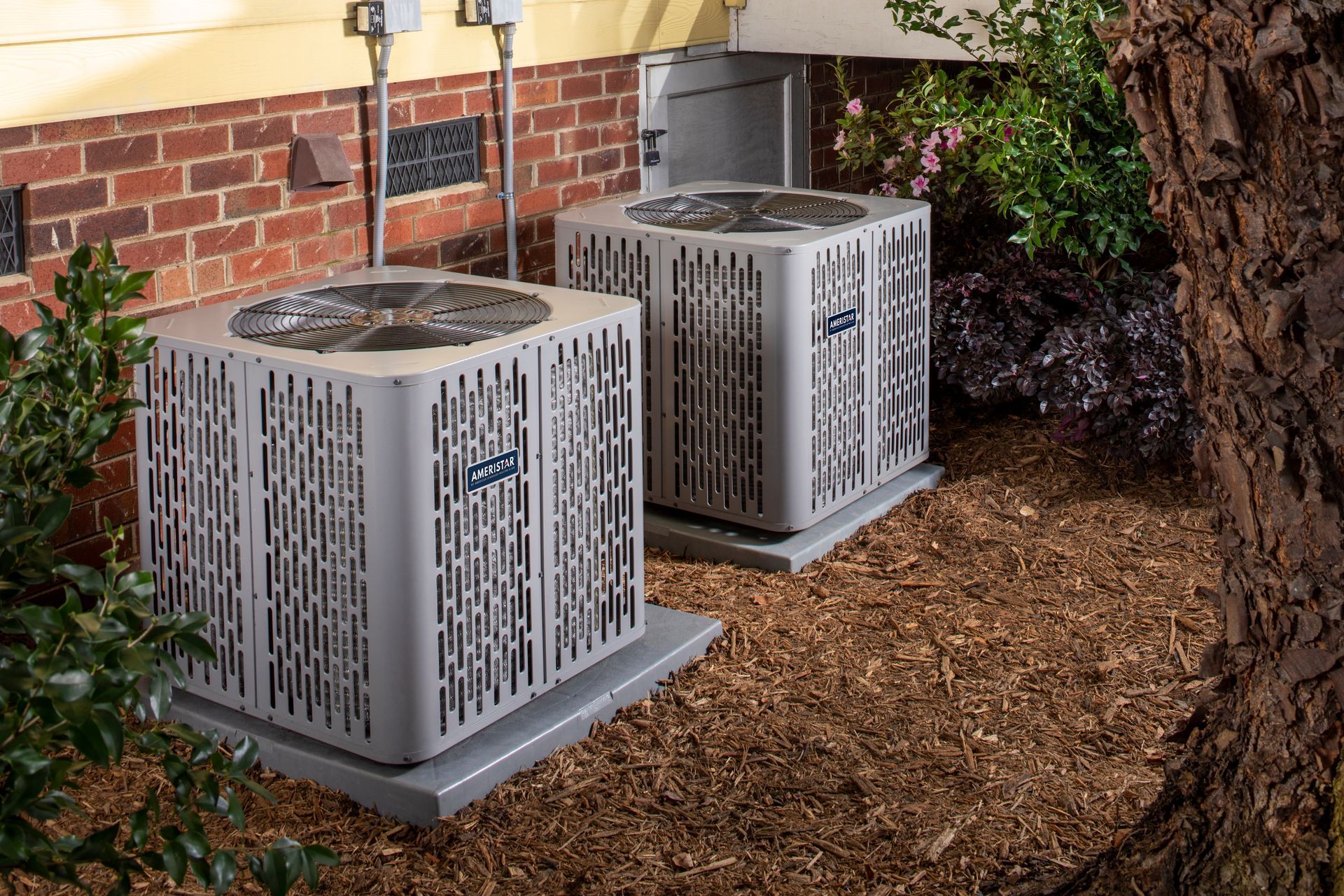 Outdoor HVAC condenser unit on gravel beside a building