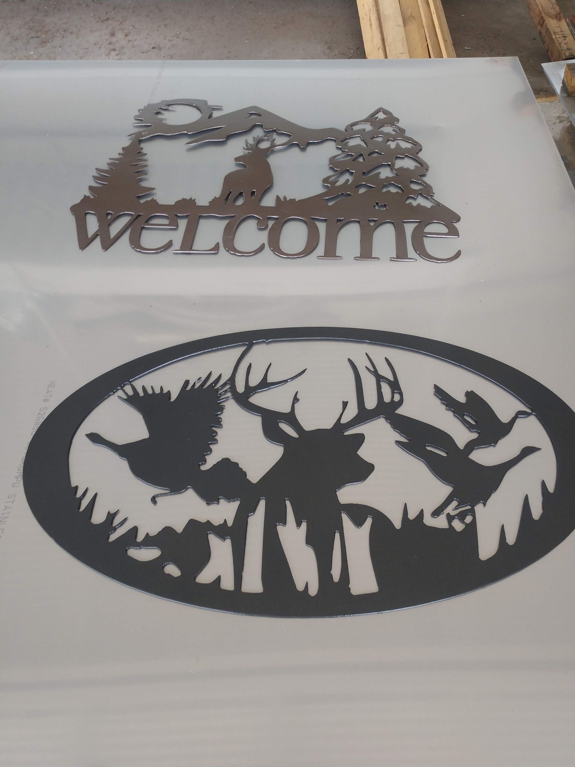 A welcome sign with a deer and birds on it.
