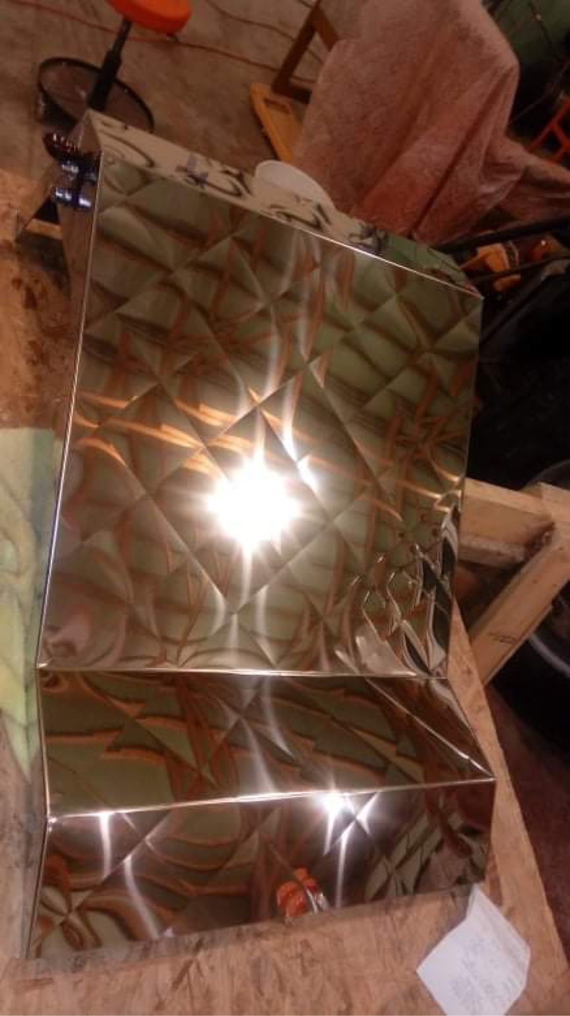 A stainless steel box is sitting on top of a wooden table.