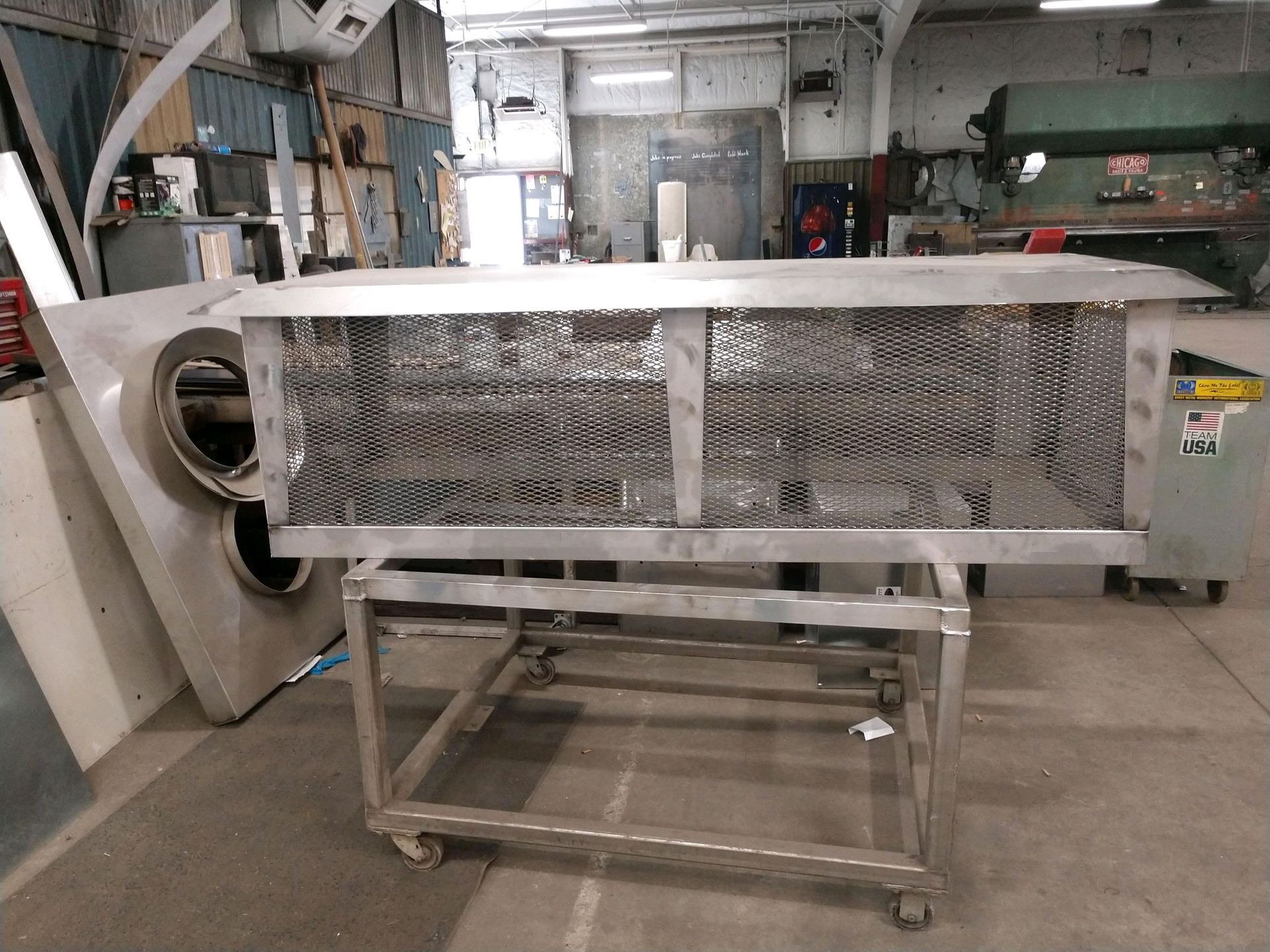 A large piece of metal is sitting on a cart in a factory.