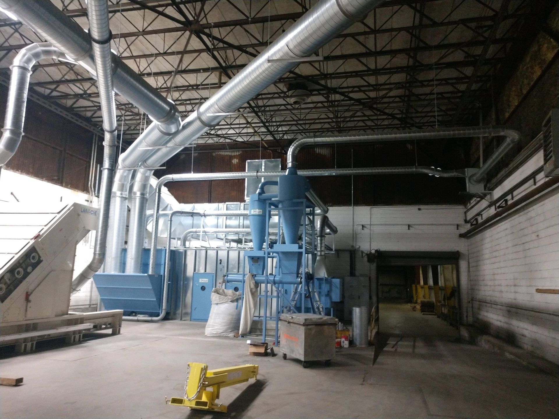 A large warehouse with a lot of pipes and machinery.