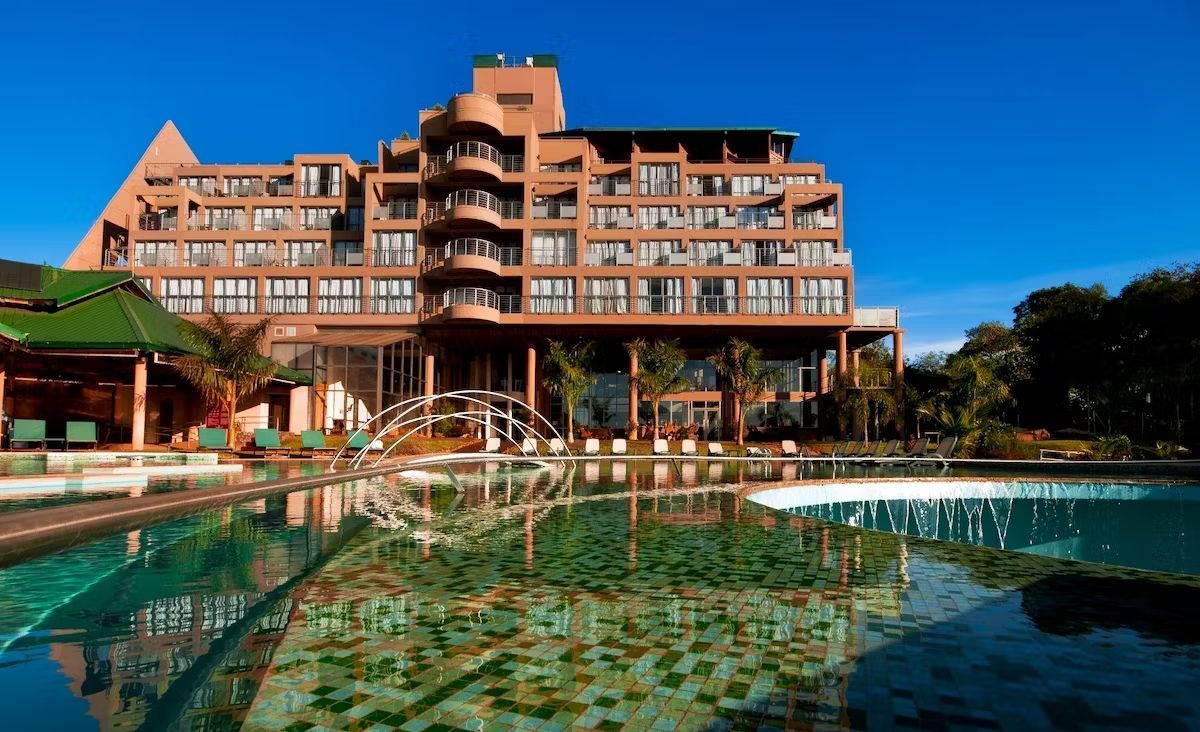 Un edificio grande con una piscina enfrente.
