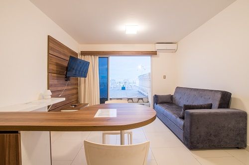Un salón con sofá, mesa y televisión.