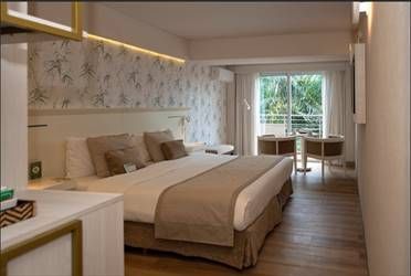 Una habitación de hotel con una cama grande y una puerta corredera de cristal.
