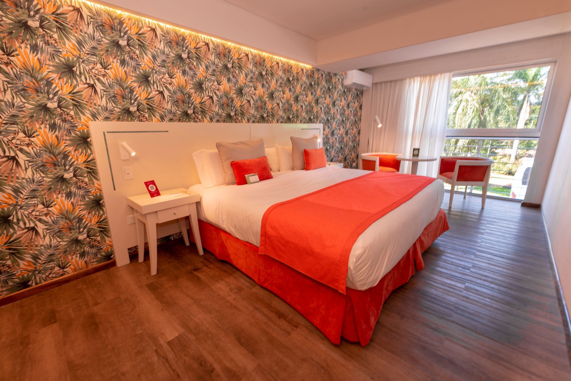 Una habitación de hotel con una cama king size y un gran ventanal.