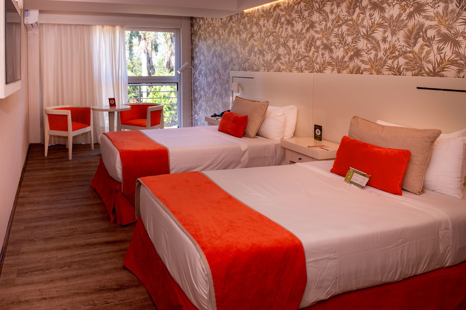 Una habitación de hotel con dos camas, una mesa y sillas.