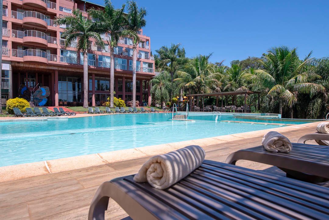 Una gran piscina con un hotel al fondo.