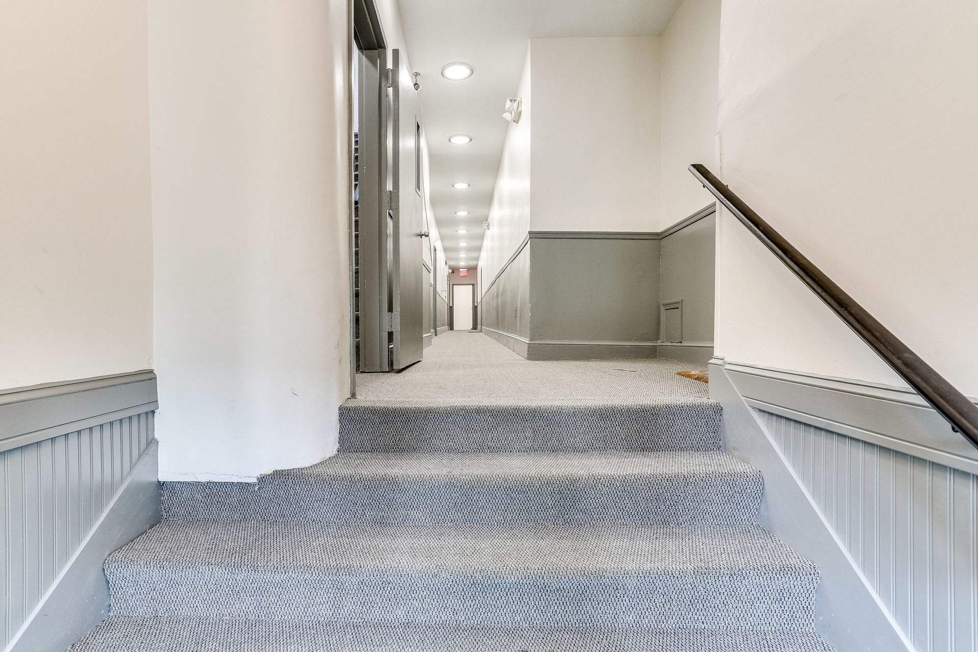 A set of stairs leading up to a hallway in a building.