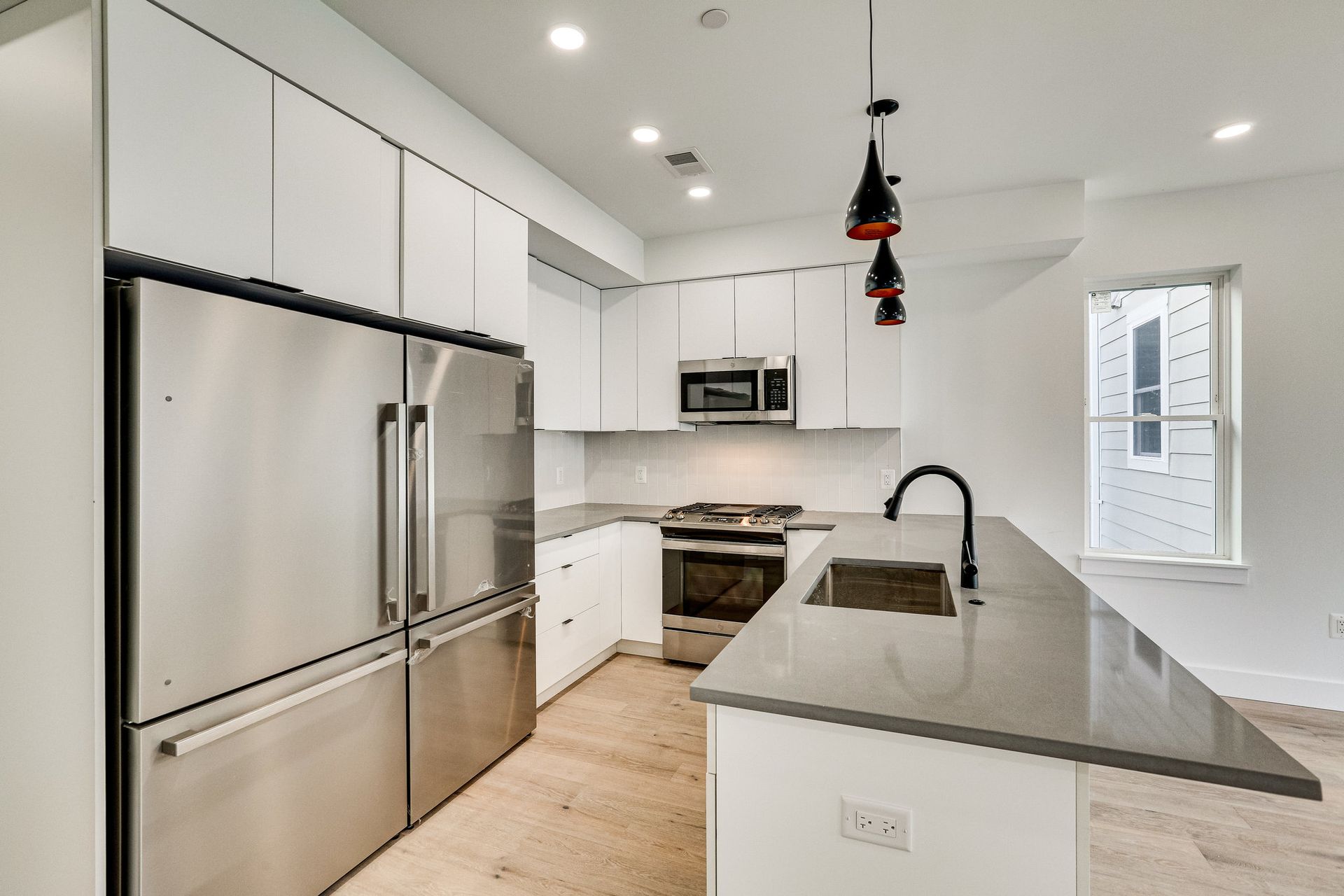 A kitchen with stainless steel appliances and white cabinets