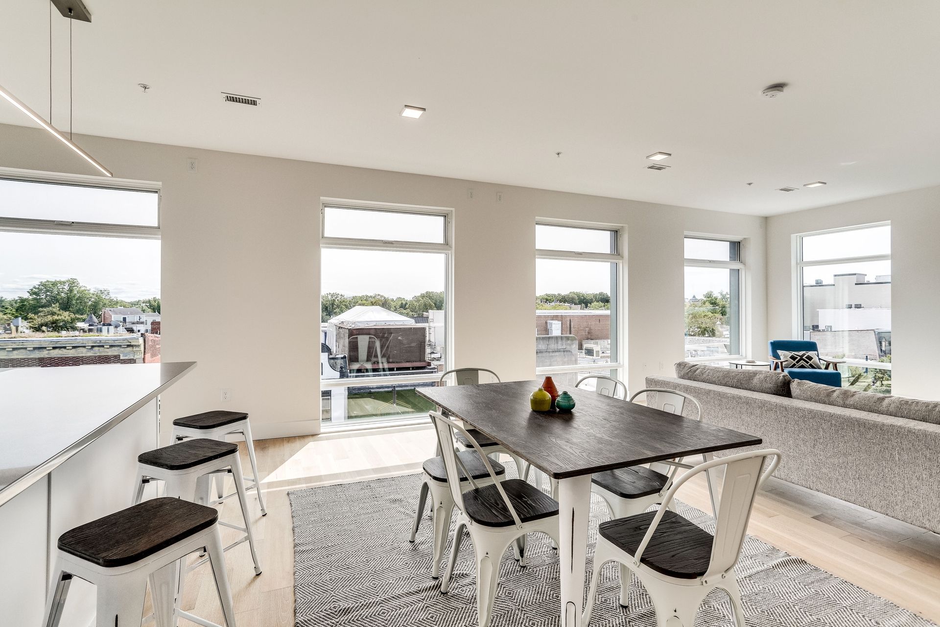 A dining room with a table and chairs and a couch.