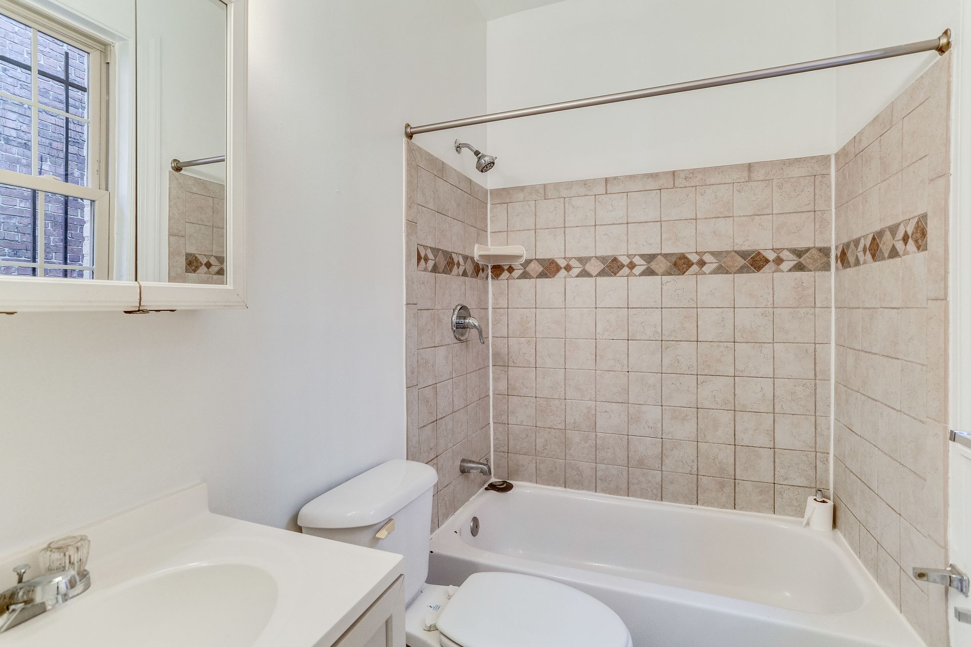 A bathroom with a toilet , sink and bathtub.