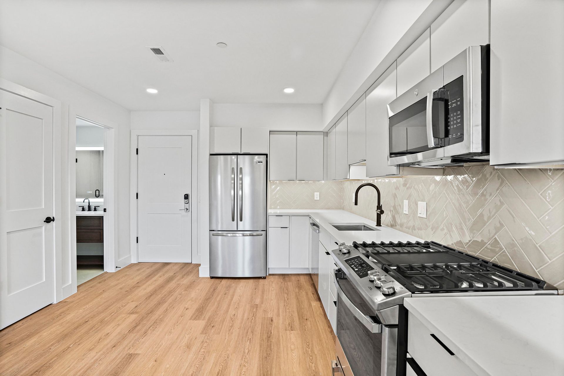 A kitchen with stainless steel appliances and white cabinets
