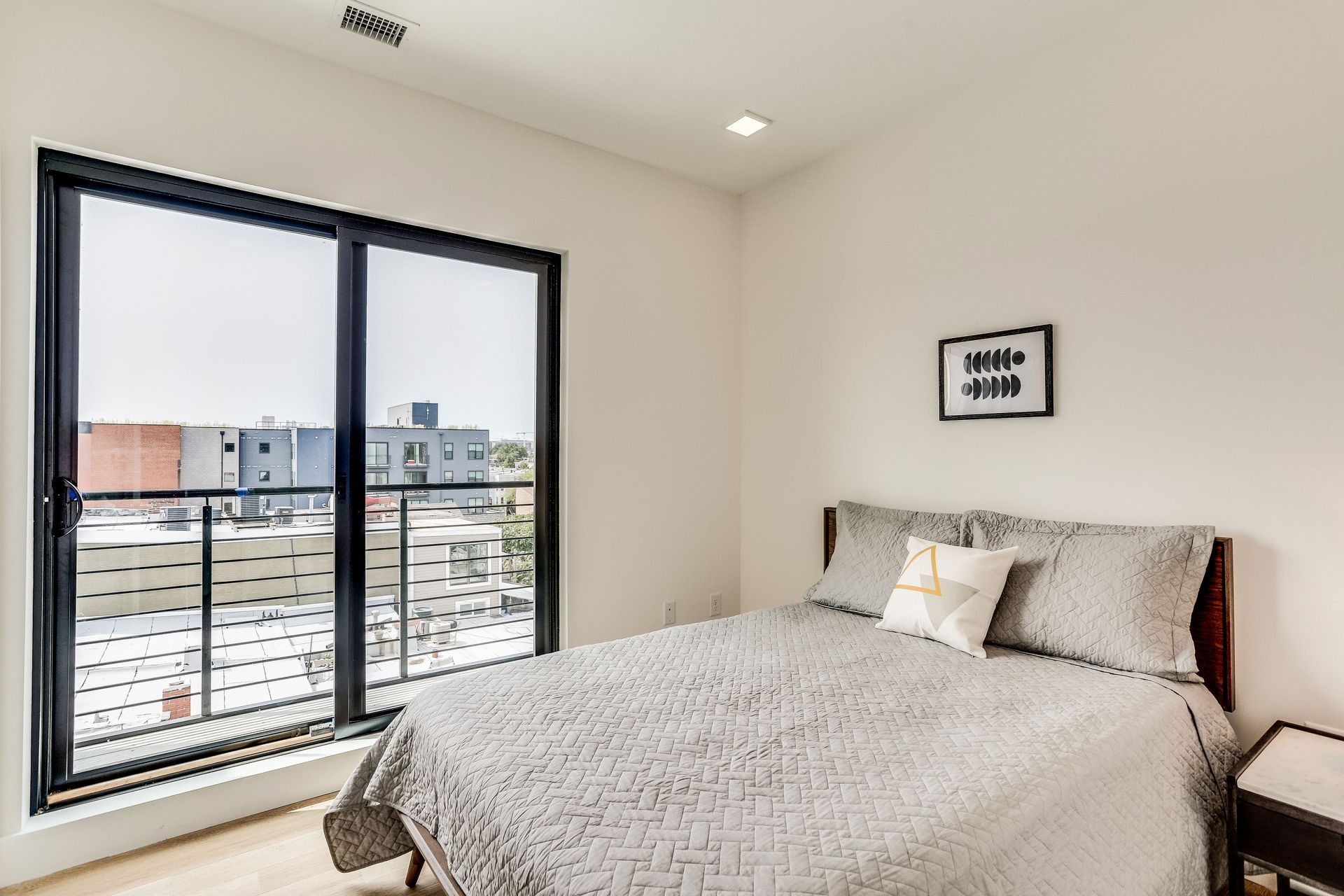 A bedroom with a large bed and a balcony
