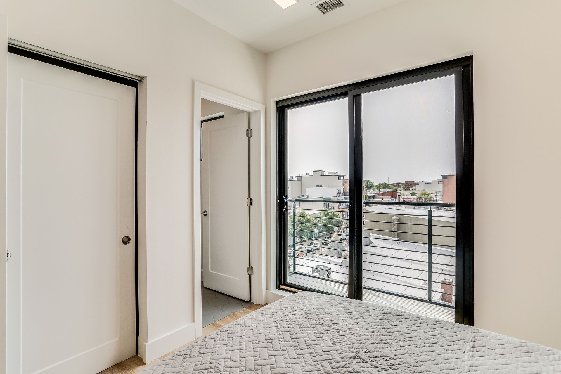 A bedroom with sliding glass doors and a balcony.