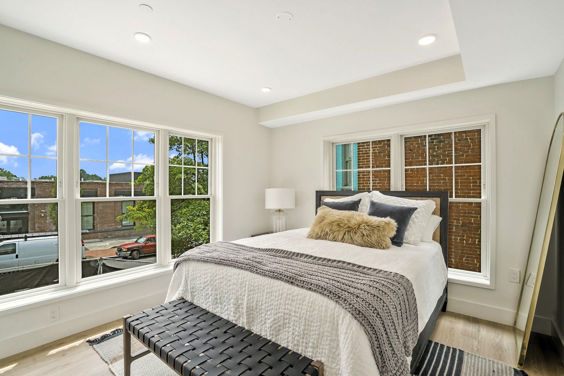 A bedroom with a bed and a bench in front of a window.