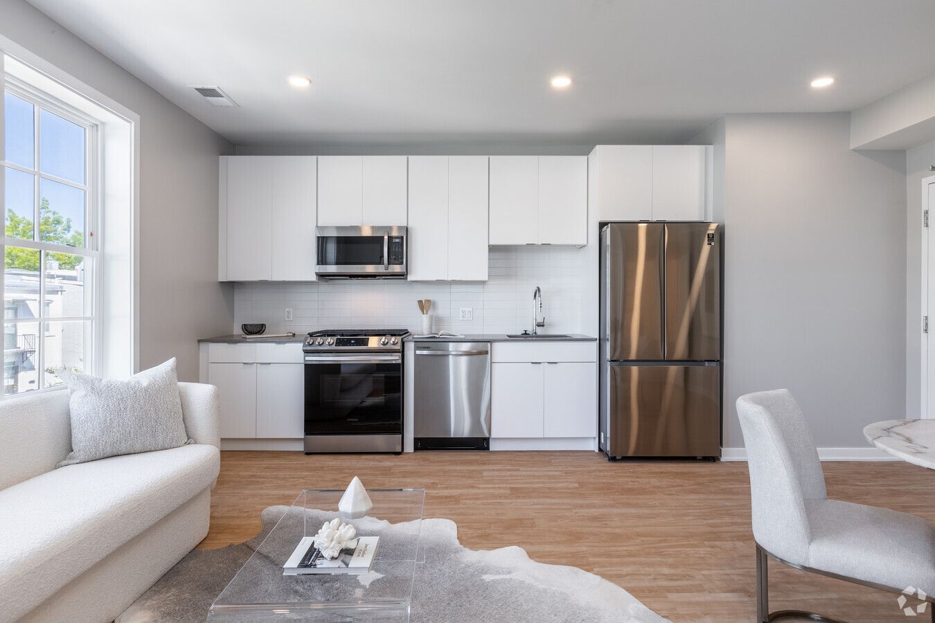 A living room with a couch a table and a refrigerator