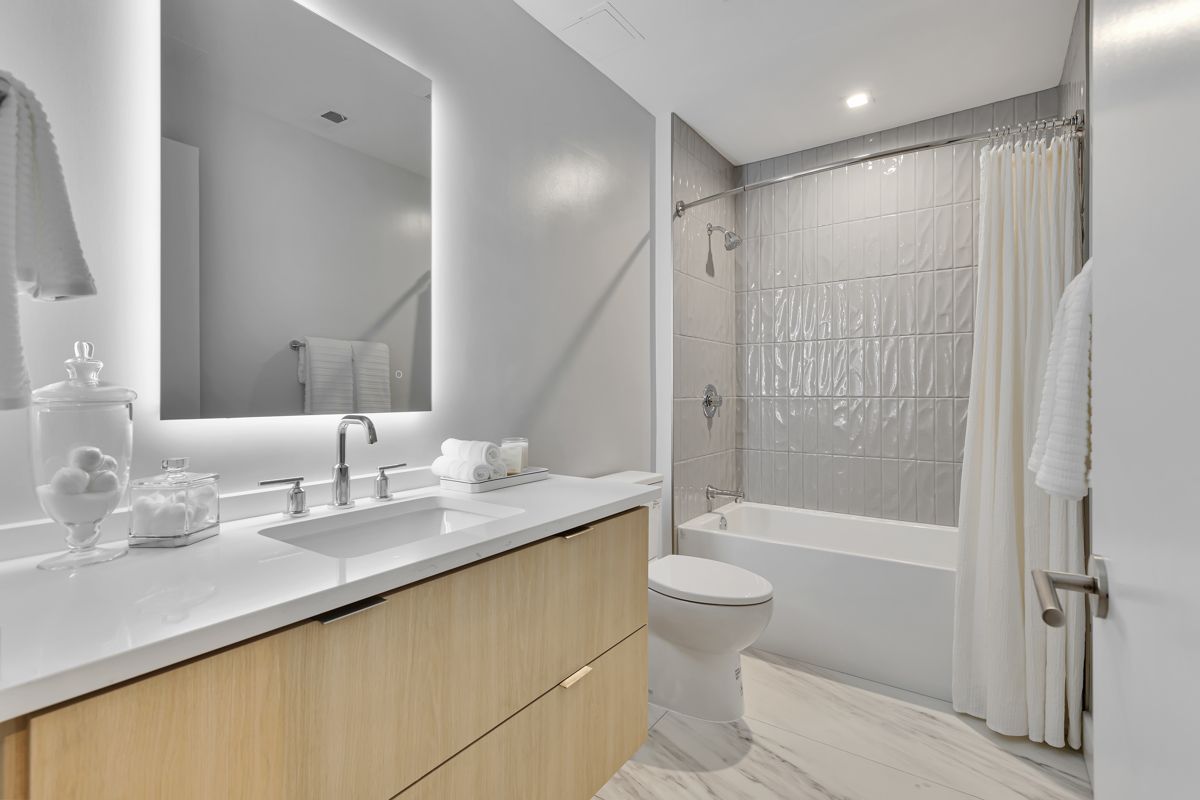 A bathroom with a sink , toilet , bathtub and mirror.